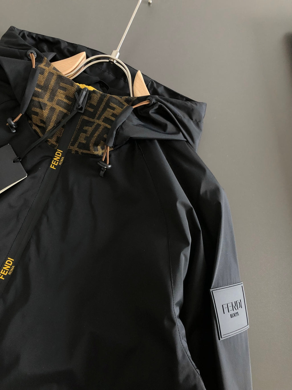 Black jacket front with hood and tan-brown FENDI logo panel detail