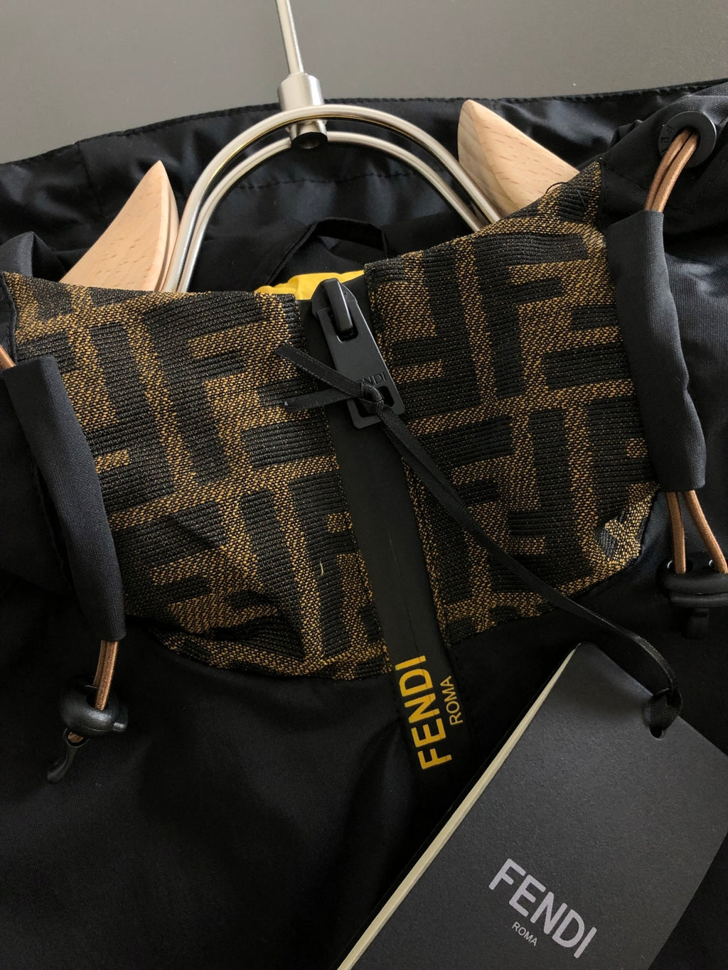 Black jacket with tan and brown patterned FENDI trim and drawstring hood