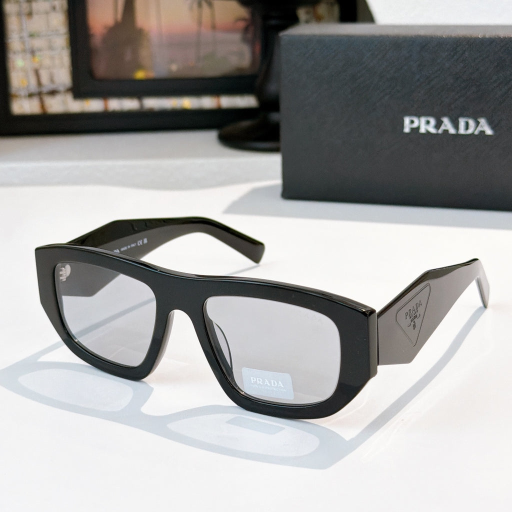 Sunglasses with black frames and gray-tinted lenses, Prada logo on temple