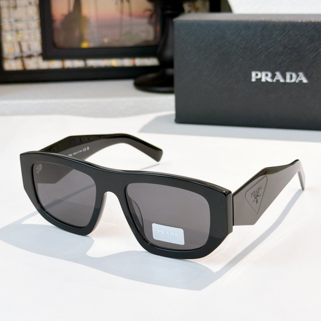 Sunglasses with black frames and dark gray lenses, Prada logo on temple