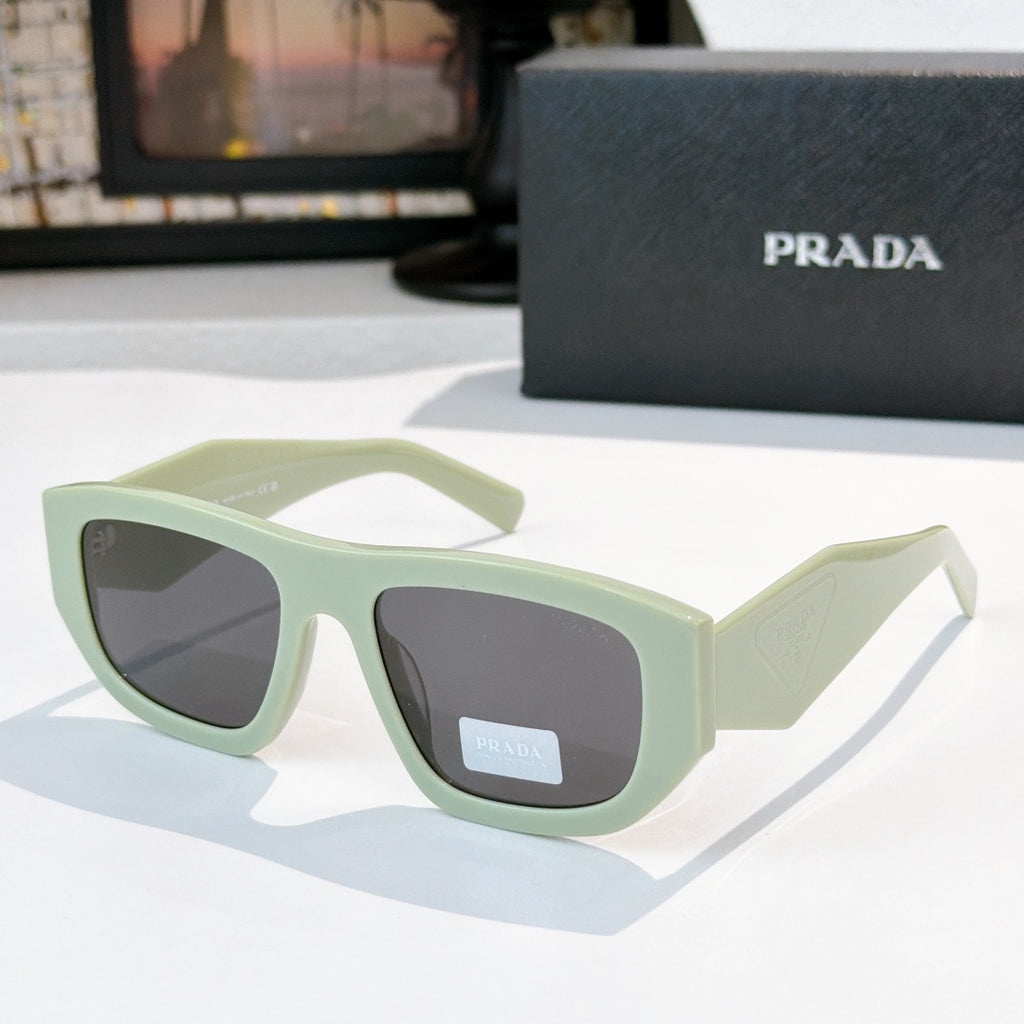 Sunglasses with pale green frames and gray-tinted lenses, Prada logo on temple