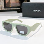 Sunglasses with pale green frames and gray-tinted lenses, Prada logo on temple