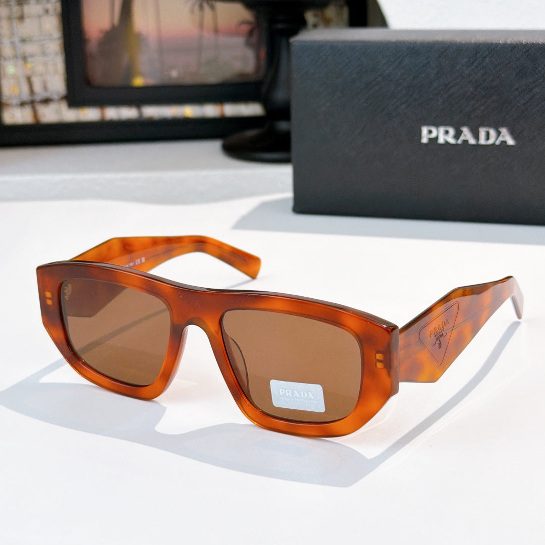 Sunglasses with orange-brown frames and brown-tinted lenses, Prada logo on temple
