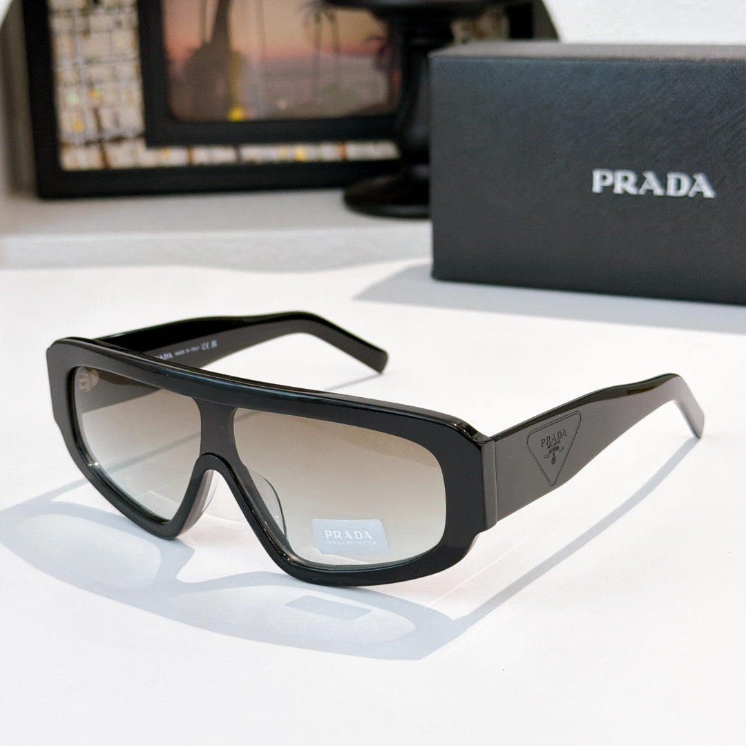 Prada sunglasses in black with tinted lenses and faceted full-rim frame