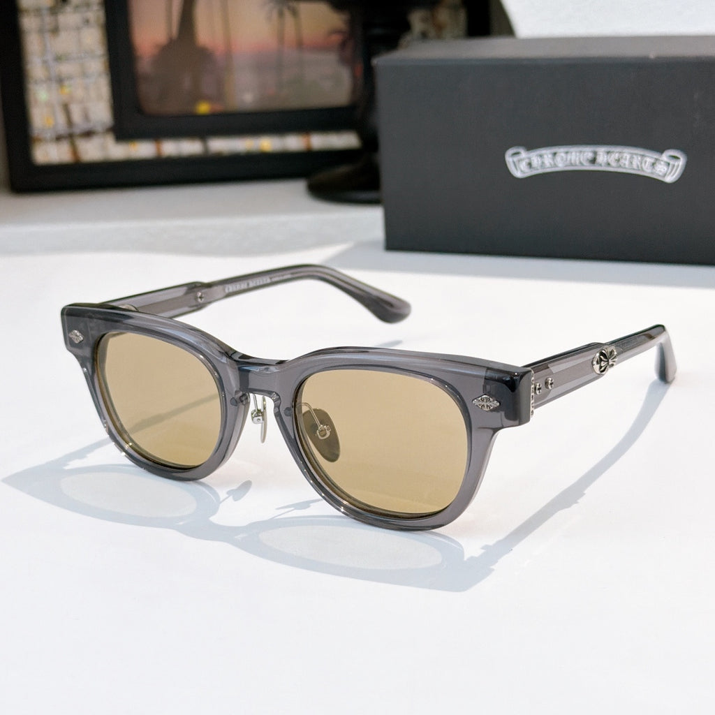 Oval sunglasses with dark frame and brown tinted lenses, metal temples and arms.