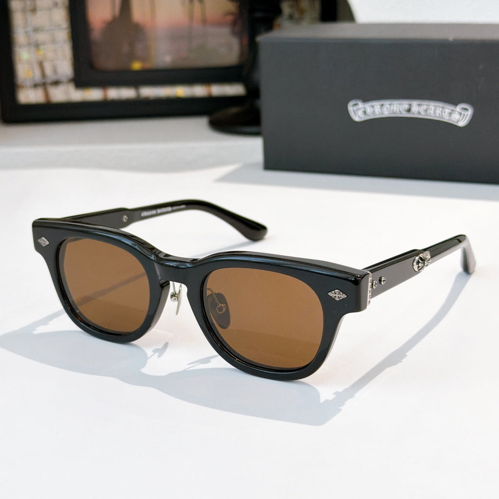 Oval sunglasses with black frame and brown tinted lenses, metal temples and arms.