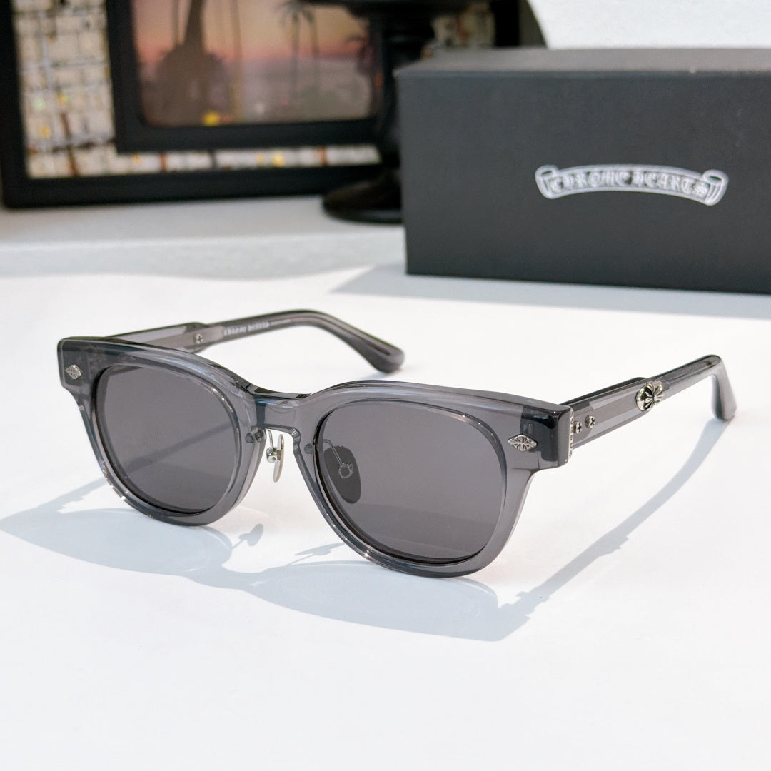 Oval sunglasses with dark gray frame and dark gray tinted lenses, metal temples and arms.