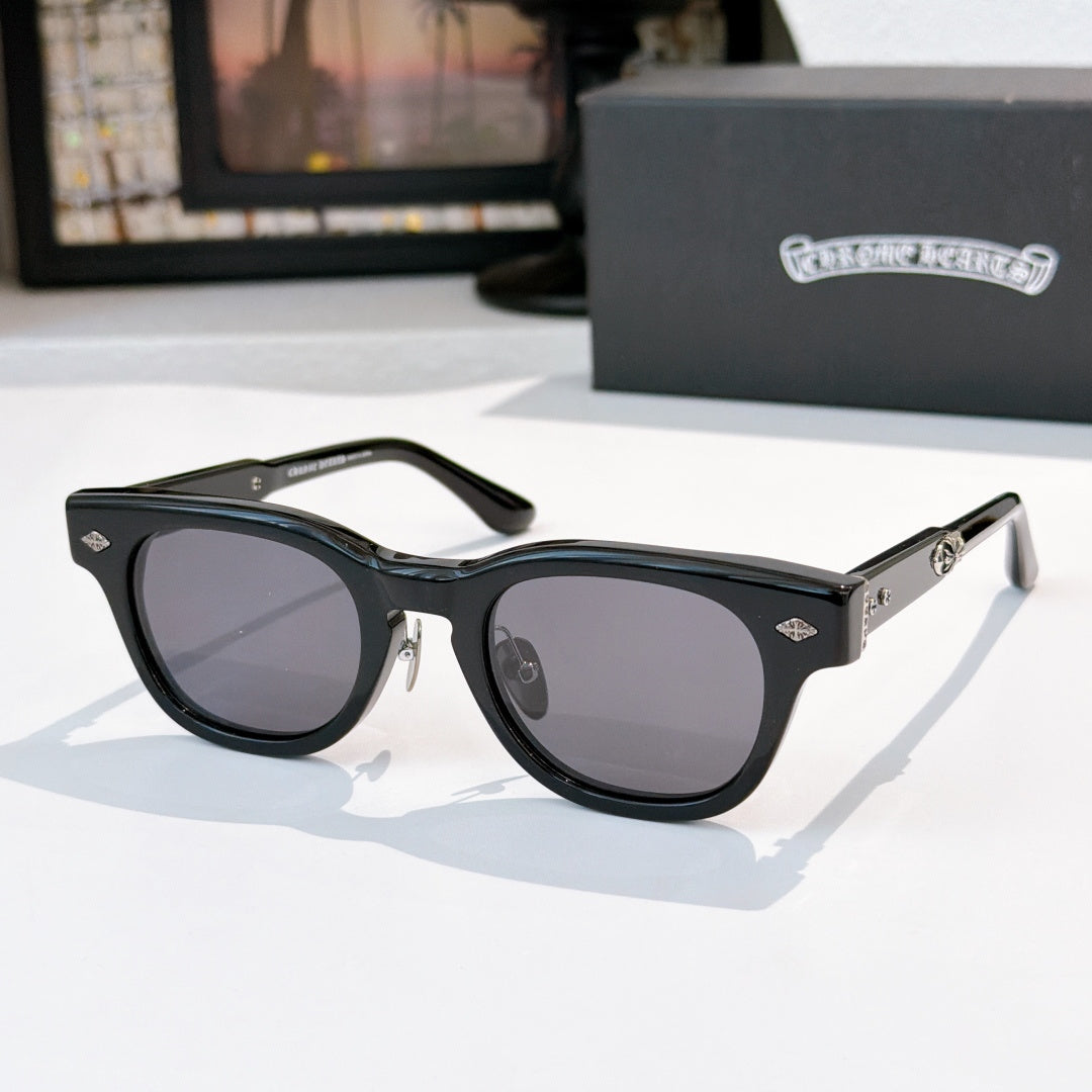 Oval sunglasses with black frame and dark gray tinted lenses, metal temples and arms.