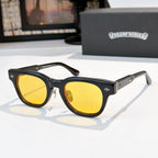 Oval sunglasses with black frame and yellow tinted lenses, metal temples and arms.