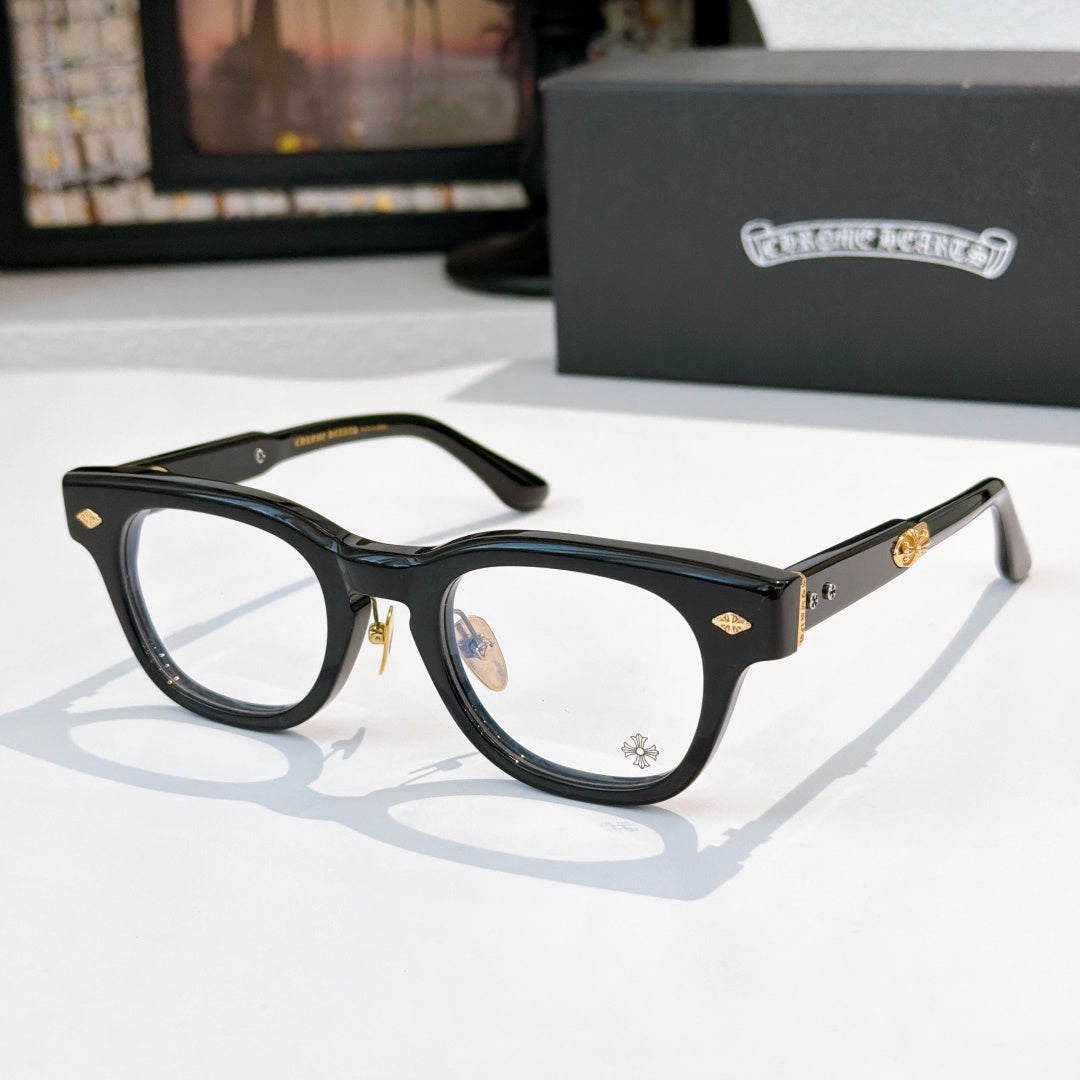 Glasses with black frames and clear lenses, gold-tone temple accents