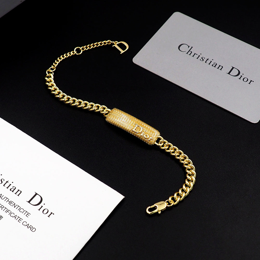 Dior gold-tone chain bracelet with textured bar charm and D clasp closure.