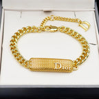 Dior gold-tone chain bracelet with textured bar charm and D clasp on gift box.