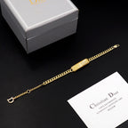 Dior gold-tone chain bracelet with rectangular textured logo bar detail.