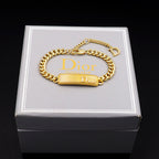 Dior gold-tone chain bracelet with textured bar charm and D clasp on box lid.