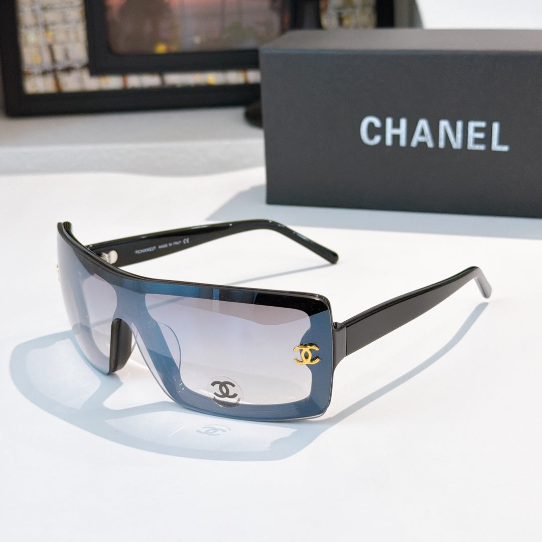 Chanel sunglasses, dark frame with light blue lens tint and gold CC logo on temple