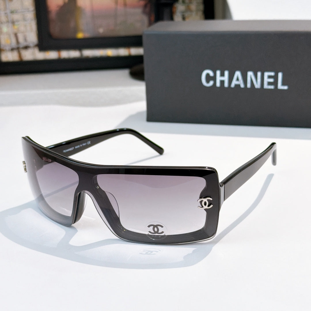 Chanel sunglasses, dark frame with pale purple lens tint and gold CC logo on temple