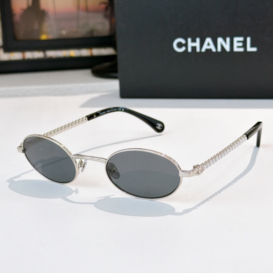 Silver round sunglasses with dark gray lenses and beaded chain temples