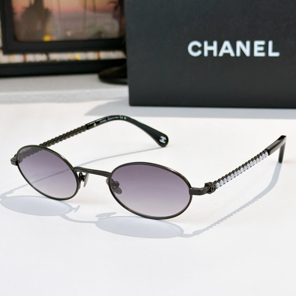 Black round sunglasses with purple lenses and beaded chain temples