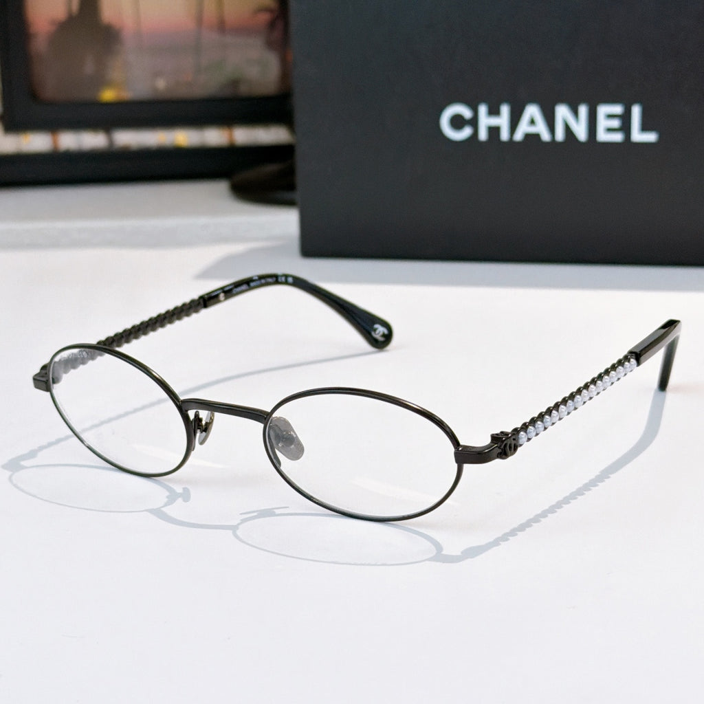 Black round eyeglasses with clear lenses and beaded chain temples