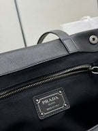 Prada Milano leather patch label on black bag beside zipper hardware
