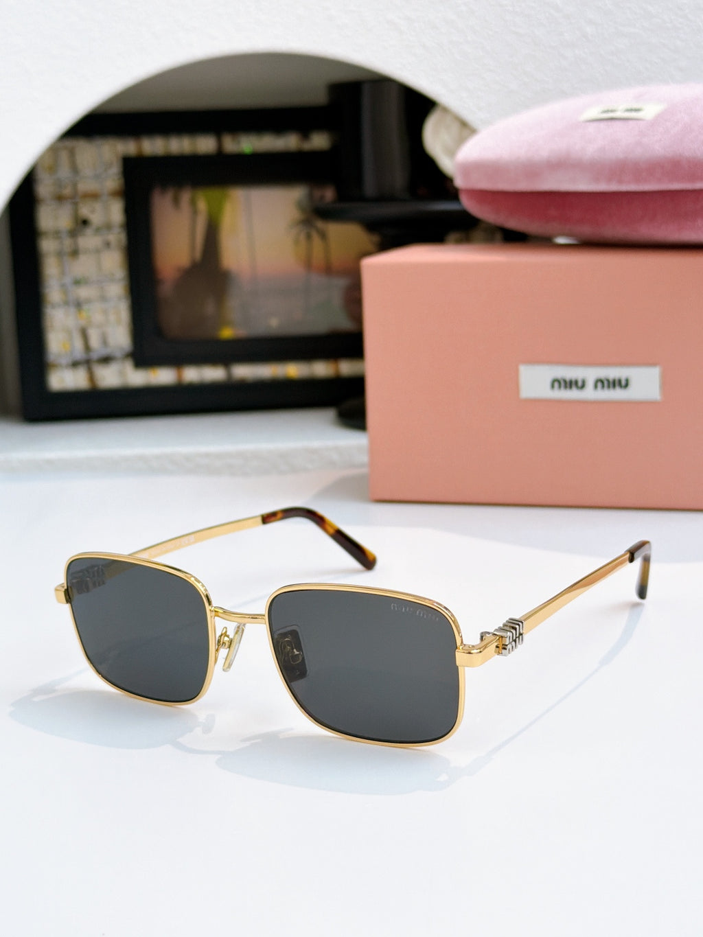 MiuMiu glasses with dark gray lenses and gold square frame