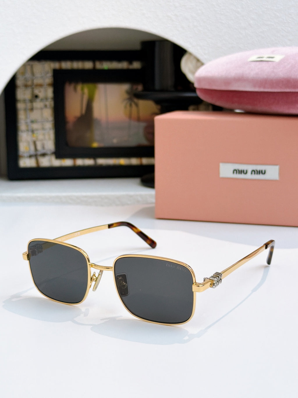 MiuMiu glasses with dark gray lenses and gold square frame