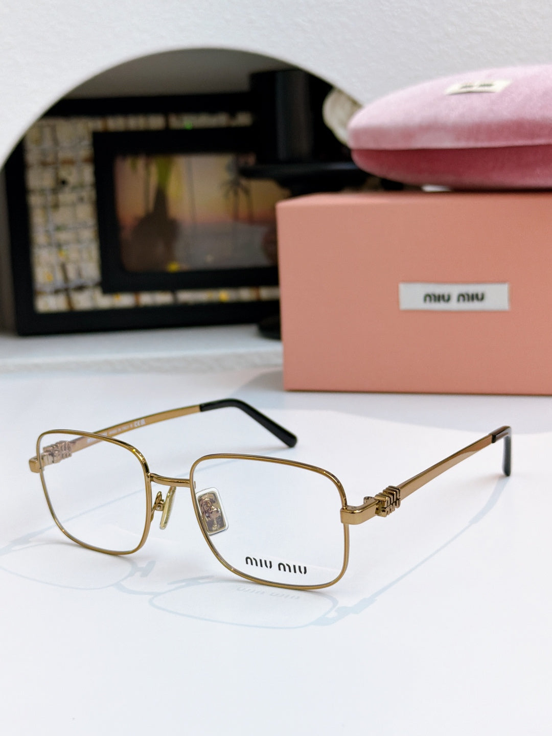 MiuMiu glasses with clear lenses and gold frame with side arms