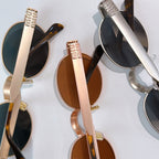 MiuMiu sunglasses detail close-up with logo temples and round tinted lenses