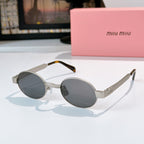 MiuMiu sunglasses with gold-tone round frames, dark gray lenses, tortoise-pattern temples