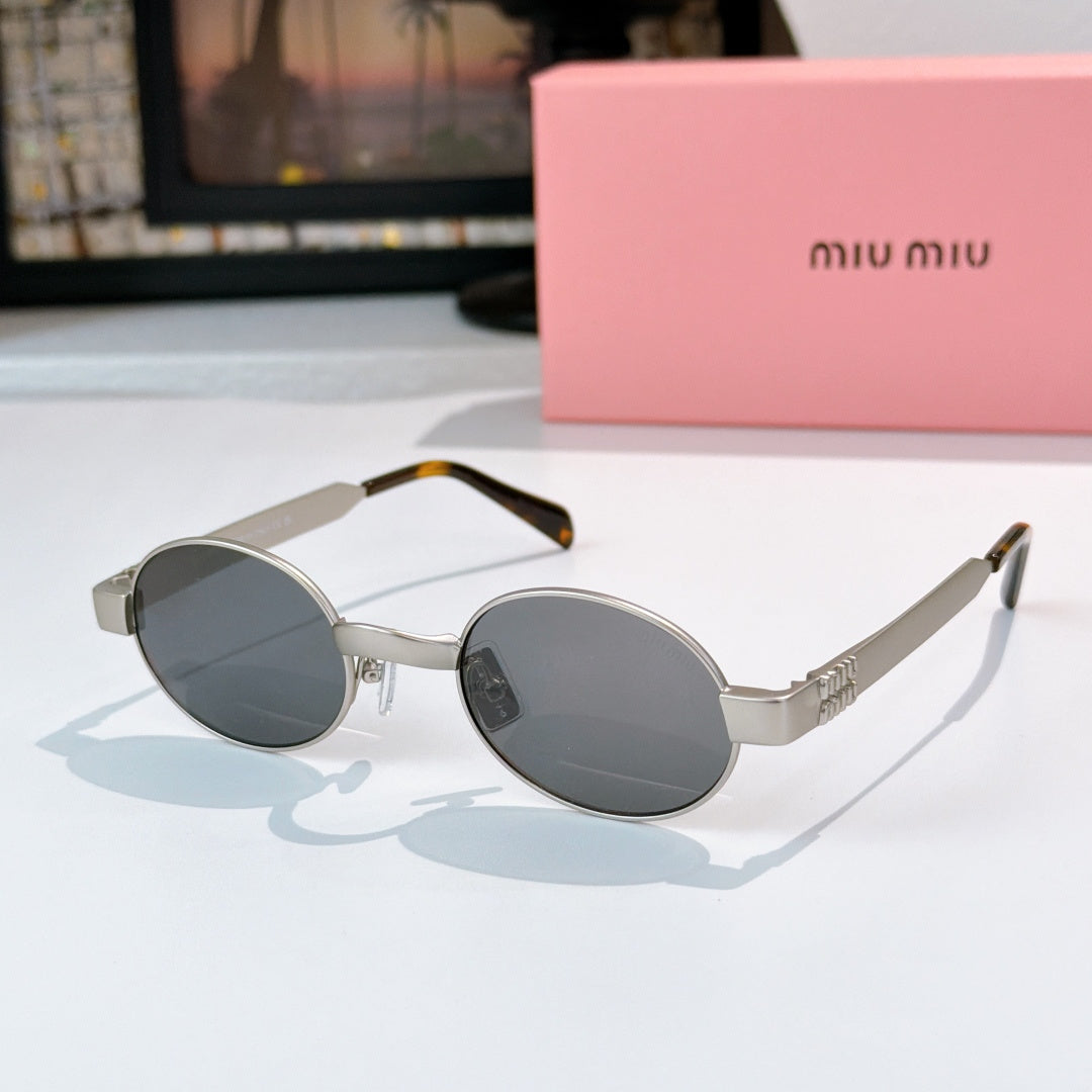 MiuMiu sunglasses with gold-tone round frames, dark gray lenses, tortoise-pattern temples