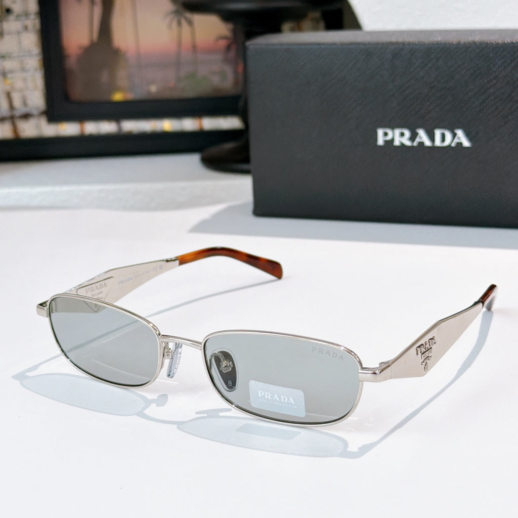 Prada sunglasses, silver frame with amber temple tips, gray lenses