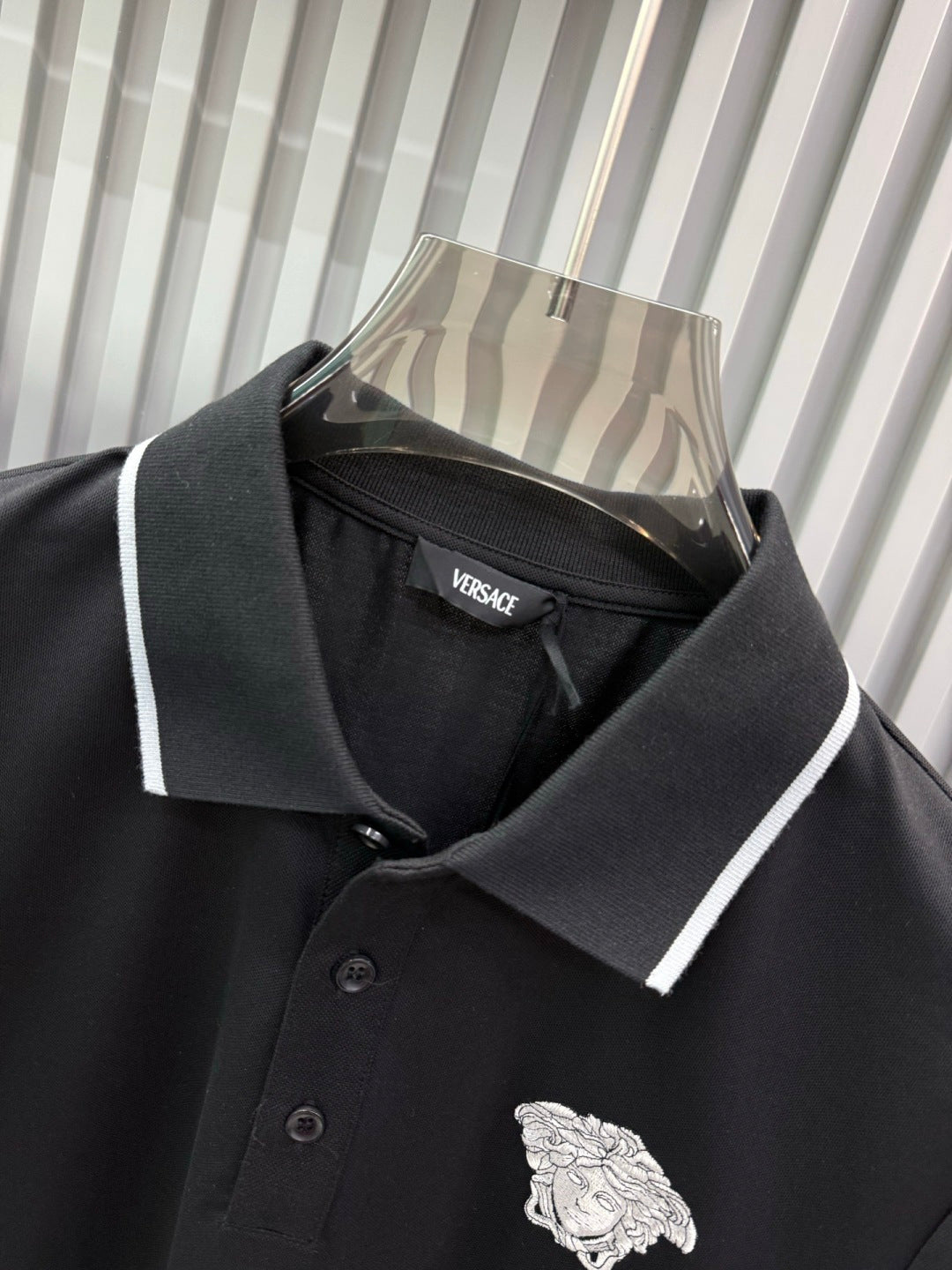 Black Versace polo shirt with white-trim collar, button placket, Medusa crest