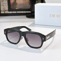 Dior sunglasses with black frames and dark gray gradient lenses.