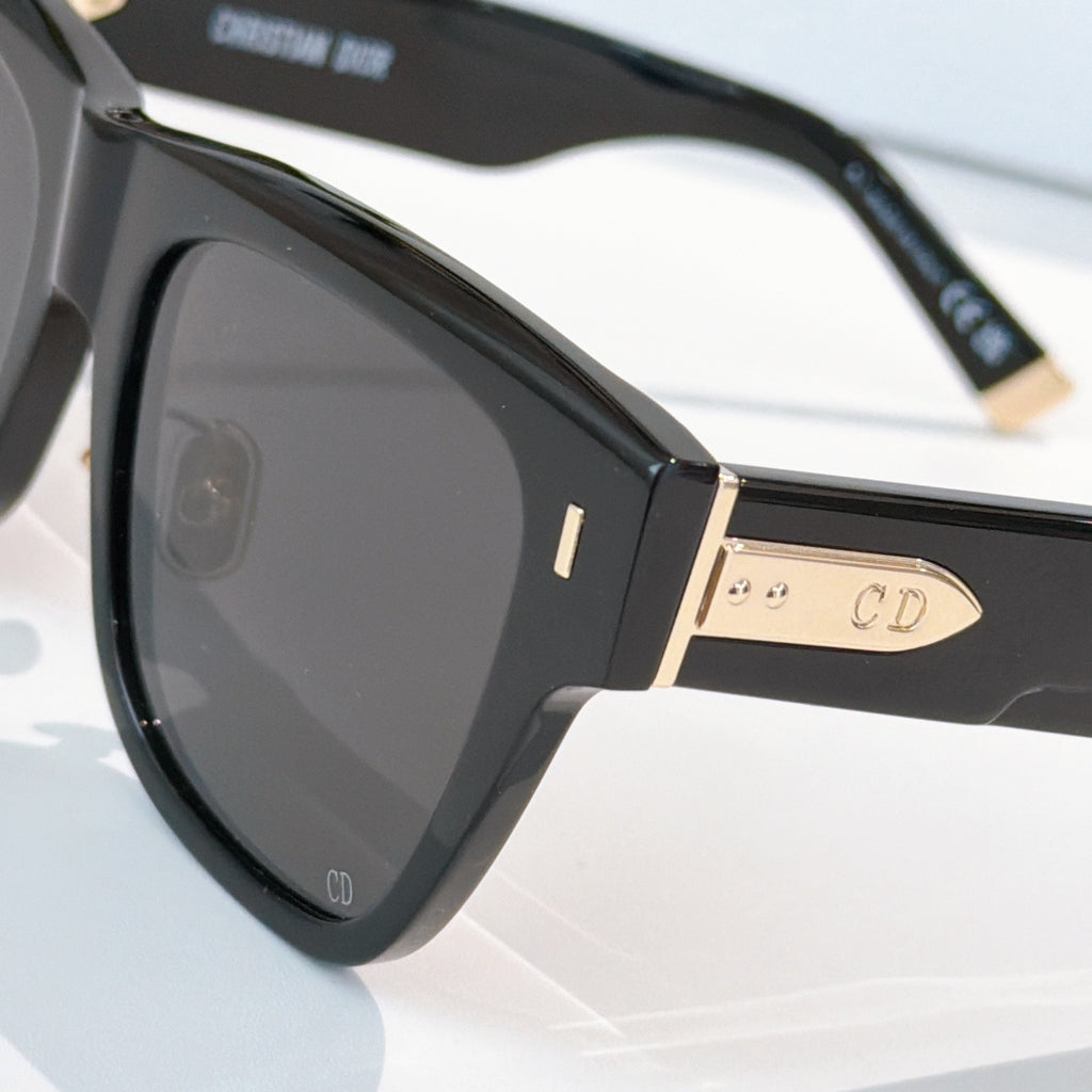 Dior sunglasses close-up, black frame with gold-tone details