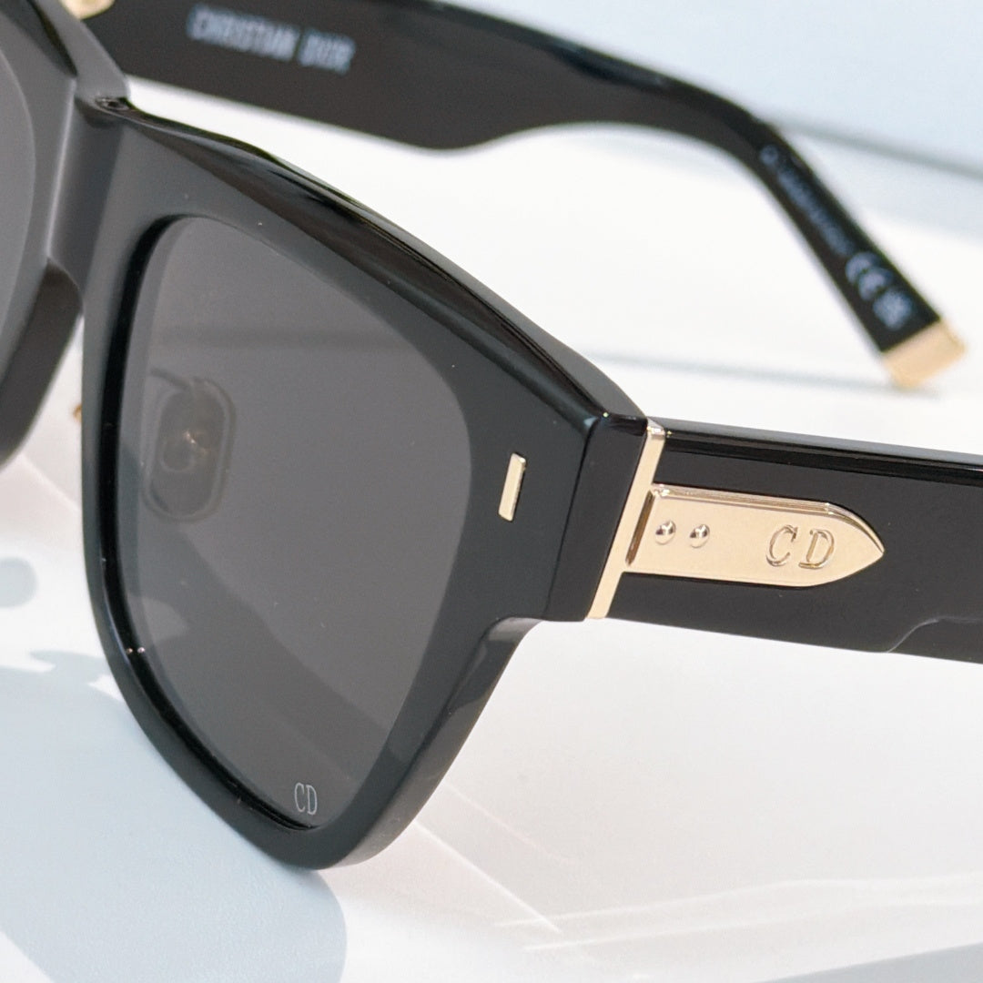 Dior sunglasses close-up, black frame with gold-tone details