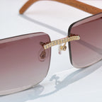 Side view of square sunglasses with mauve tinted lens and gold rhinestone bar across frame