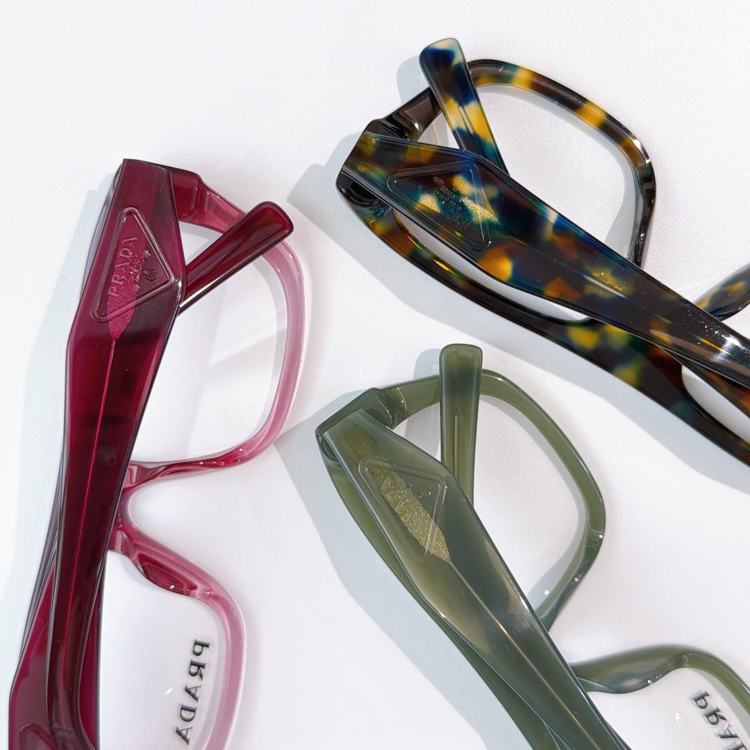 Prada eyeglass frames: red, tortoiseshell, and green