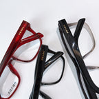 Prada eyeglasses set with red and black frames, clear lenses.