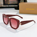 Sunglasses with burgundy frames and pink tinted lenses, gold logo detail