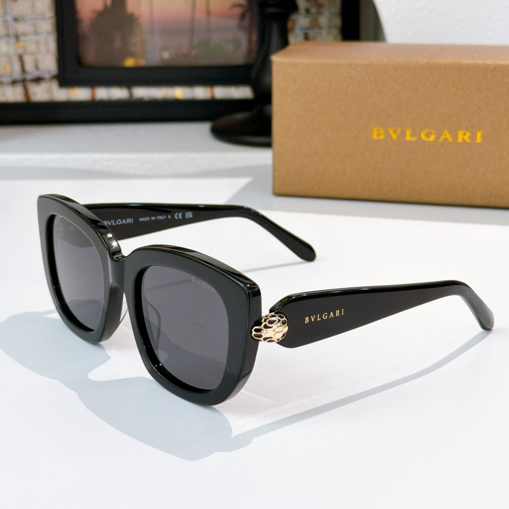Sunglasses with black frames and dark gray tinted lenses, gold logo detail