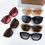 Assorted sunglasses with red, tortoiseshell, blue, and tan frames, all with tinted lenses