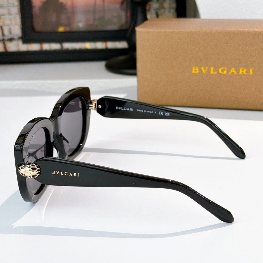 Sunglasses with black frames and dark lenses, gold logo detail on temples
