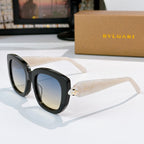 Sunglasses with black frames, pale cream temples, and blue tinted lenses