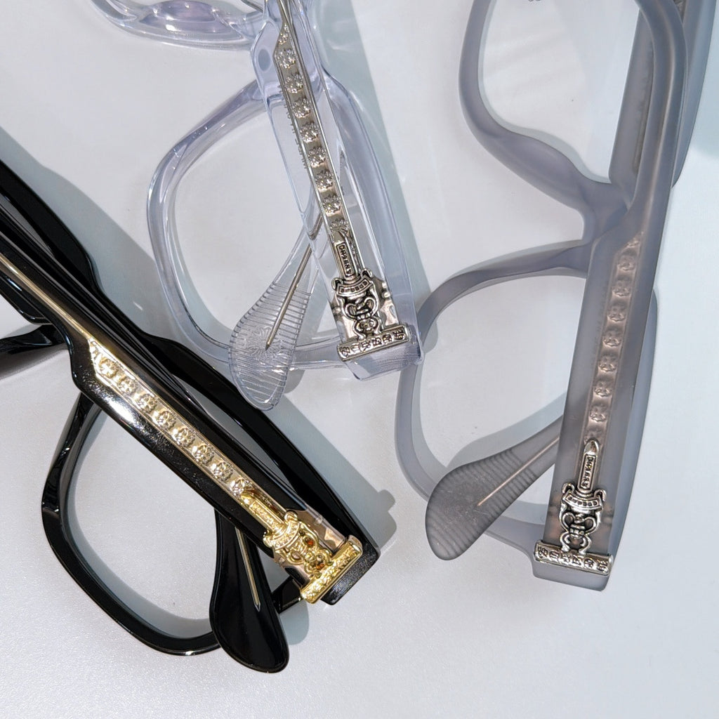 Close-up of black and clear square eyeglass frames with ornate jeweled temple inserts