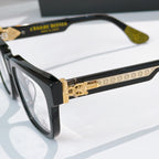 Close-up of black square eyeglass frame with gold-toned decorative temple bar