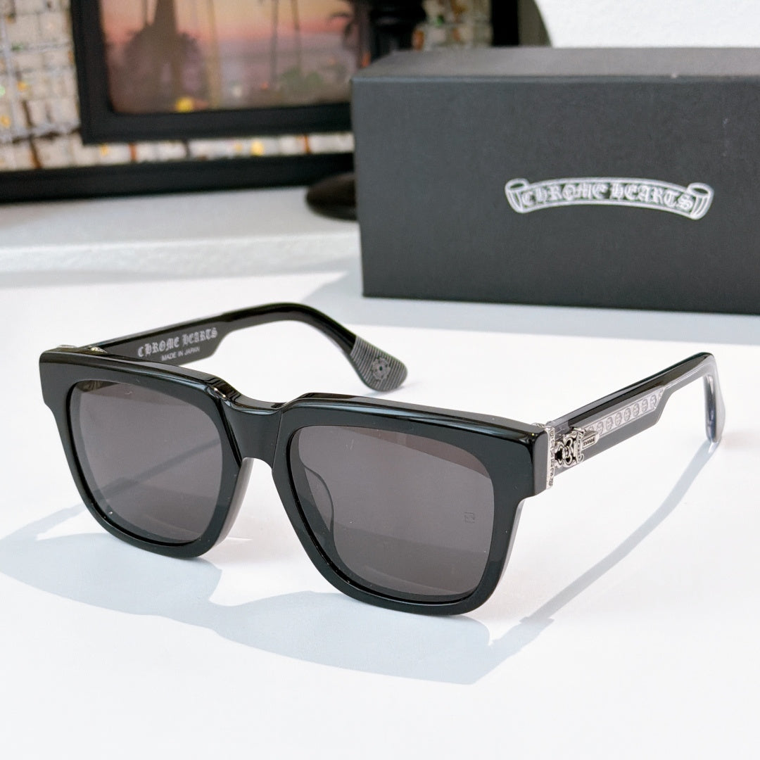 Dark-lens sunglasses with black frames and gold-engraved side lettering