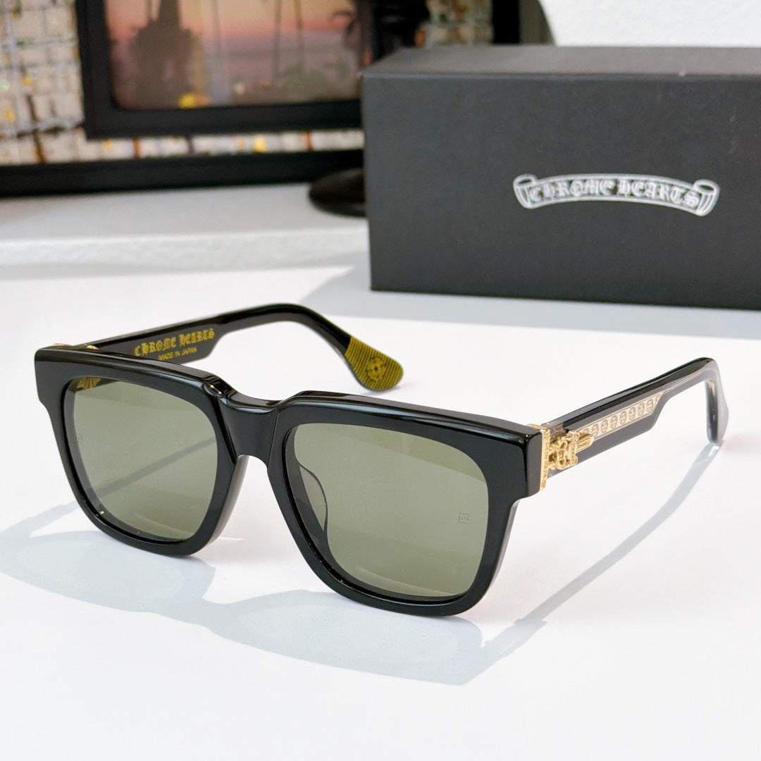 Olive-tinted sunglasses with black frames and gold side emblem detail