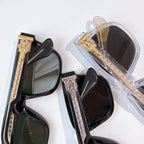 Sunglasses set in clear packaging with gold accents and dark lens frames