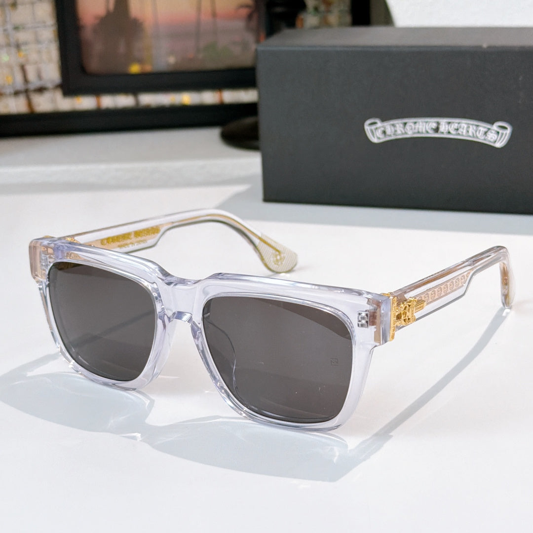 Smoke-tinted sunglasses with clear frames and gold side emblem detail