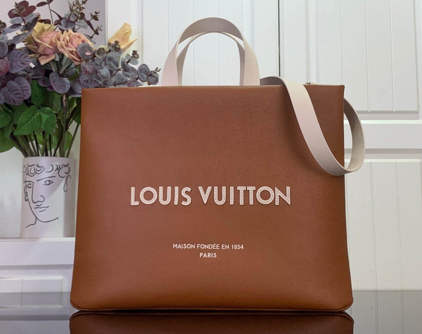 Louis Vuitton shopping bag in tan brown with top handles and printed logo
